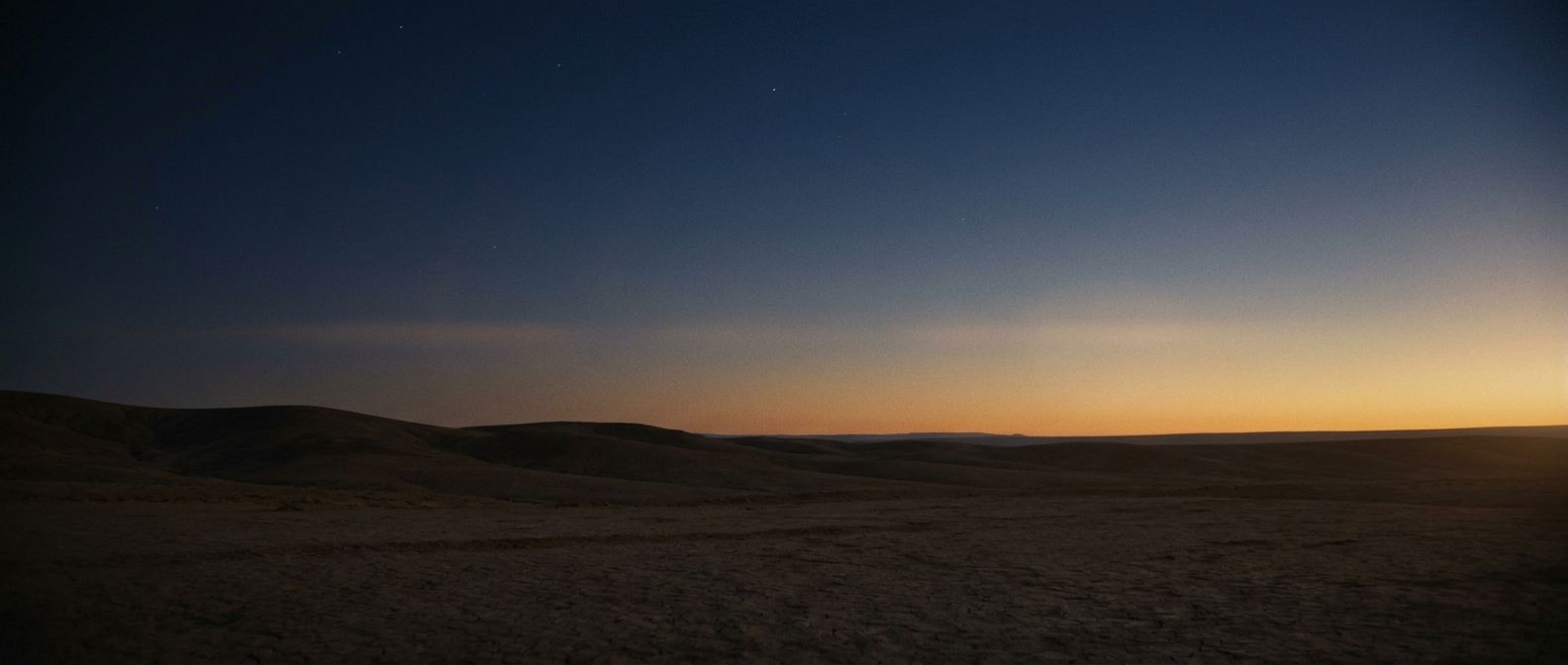 First light of dawn breaking over a dark ridge line